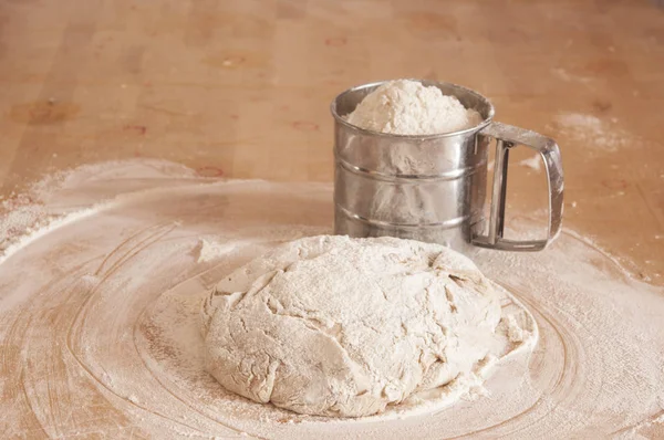 Pâte à levure de blé crue sur la table saupoudrée de farine — Photo
