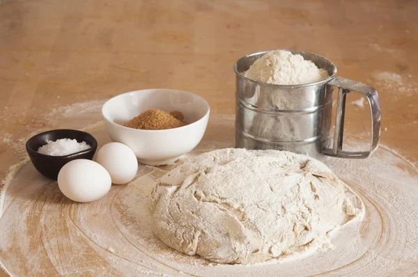 Pâte à levure de blé crue sur la table saupoudrée de farine — Photo