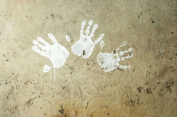 Impressions de peinture blanche à la main sur mur rugueux sombre — Photo