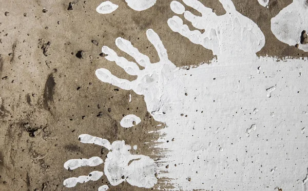 Impressions de peinture blanche à la main sur mur rugueux sombre — Photo