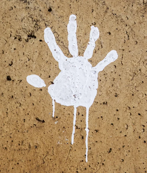 Impressions de peinture blanche à la main sur mur rugueux sombre — Photo