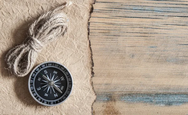 Papel velho, bússola e corda em uma mesa de madeira — Fotografia de Stock