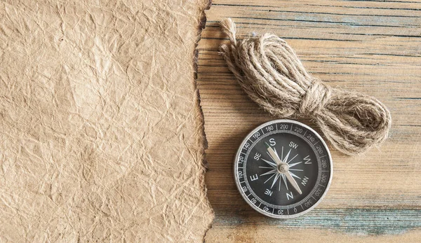 Papel viejo, brújula y cuerda sobre una mesa de madera — Foto de Stock