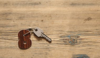 Evin anahtarı ev ahşap arka plan, gayrimenkul için kavram üzerinde dinlenme Anahtarlık şeklinde