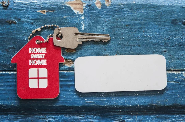 Hausschlüssel Auf Einem Schlüsselanhänger Form Eines Hauses Der Auf Holzgrund — Stockfoto