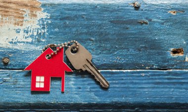 Evin anahtarı ev ahşap arka plan, gayrimenkul için kavram üzerinde dinlenme Anahtarlık şeklinde
