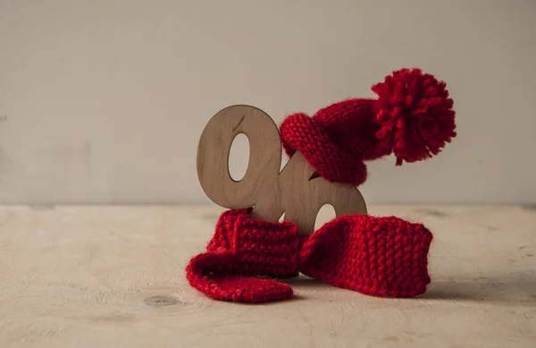 Rote Strickmütze und Schal mit Holzschild über weißem Ba — Stockfoto