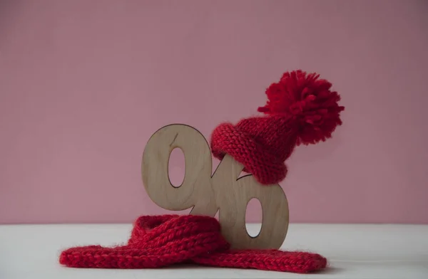 Красная вязаная шляпа и шарф с деревянным знаком процентов над белым ba — стоковое фото