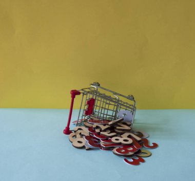 Renkli arka planda bir alışveriş arabası ve yığın numaraları