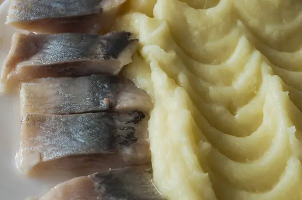 Arenque salgado e batatas cozidas em placa branca — Fotografia de Stock