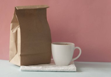 Boş kahverengi kese kağıdı ve beyaz kahve fincanı.