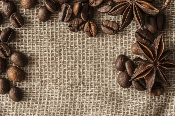 Rostade kaffebönor och krydda badian på en bakgrund av överlappning. — Stockfoto