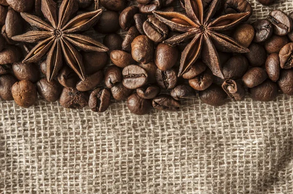 Pörkölt kávébab és fűszer badian vászonroló háttérrel. — Stock Fotó