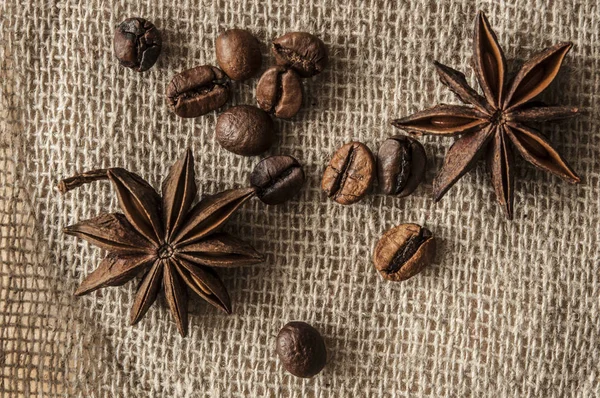 Pörkölt kávébab és fűszer badian vászonroló háttérrel. — Stock Fotó