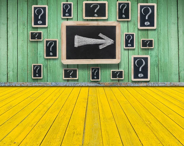 Board on a wooden wall with a chalk drawing of a question mark. — Stock Photo, Image