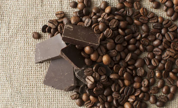 Granos de chocolate y café sobre fondo textil —  Fotos de Stock