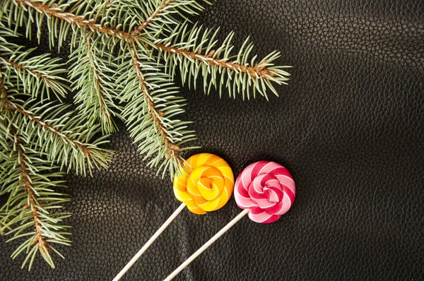 Colorful lollipop and white stick put on the black color leather