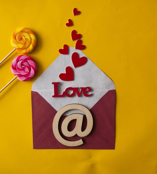 Słowo Miłość w kopercie z czerwonymi sercami na Walentynki, — Zdjęcie stockowe