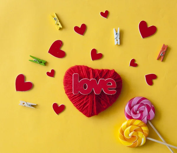 Amor palabra, corazón y caramelos lollipop sobre fondo de papel amarillo —  Fotos de Stock