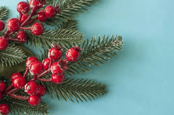 Decoraciones navideñas: bayas rojas sobre fondo azul pastel. Ch —  Fotos de Stock