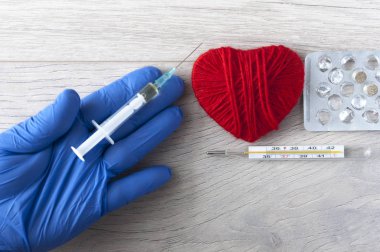 Mavi eldivenli bir elin kırmızı bir kalbi vardır. Tıbbi konsept. Anlaşıldı. 