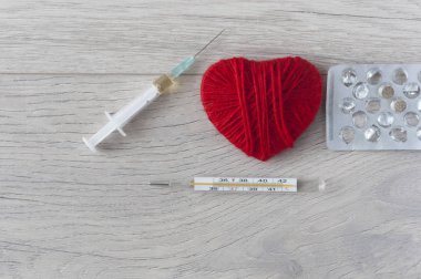 Eski bir cıva termometresi. Şırıngası ve ahşap üzerinde kırmızı kalbi var.