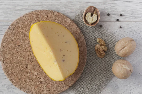 Plak kaas met walnoten op houten ondergrond — Stockfoto