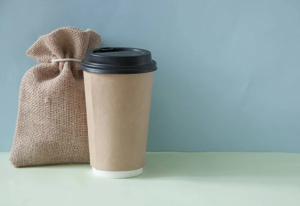 Carta tazza di caffè con sacco di iuta su sfondo colorato un — Foto Stock