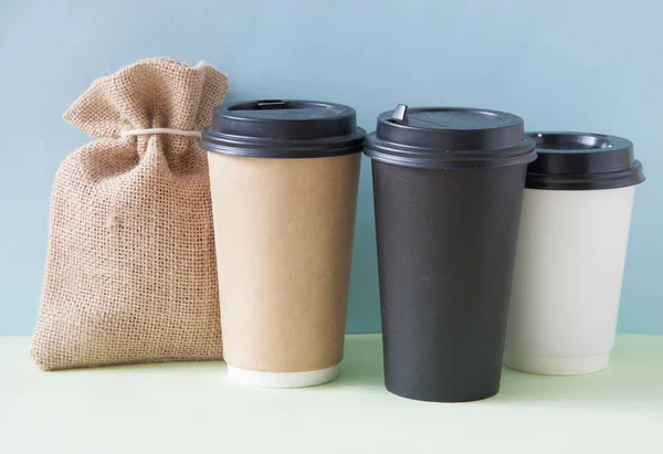 Carta tazza di caffè con sacco di iuta su sfondo colorato un — Foto Stock