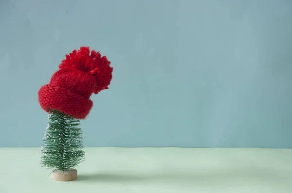 Czerwony dzianina czapka zimowa na małej dekoracji choinka tre — Zdjęcie stockowe