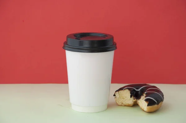 Runda röda glaserade donut och papper kopp med kaffe — Stockfoto