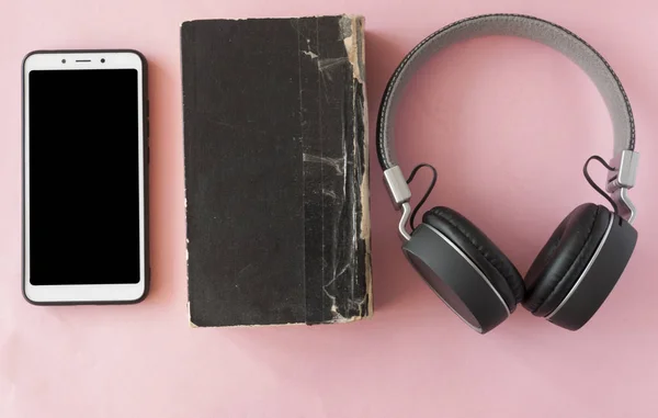 Cuffie, smartphone e libro bianco aperto. Vista dall'alto — Foto Stock