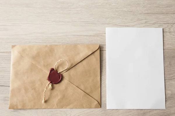 Enveloppes papier vierges sur fond de table en bois clair . — Photo