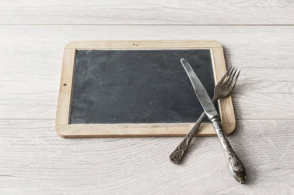 Quadro de quadro de quadro negro menu na mesa de jantar de madeira — Fotografia de Stock