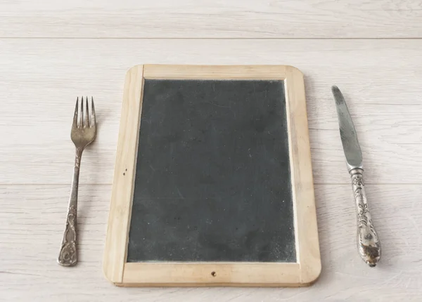 Quadro de quadro de quadro negro menu na mesa de jantar de madeira — Fotografia de Stock