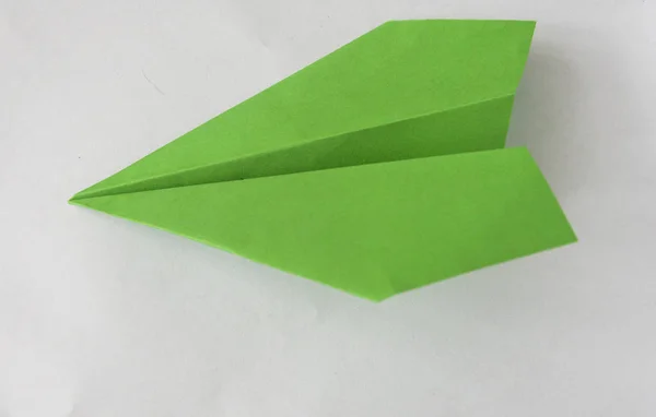 Зеленая бумага плоскости на белом фоне . — стоковое фото