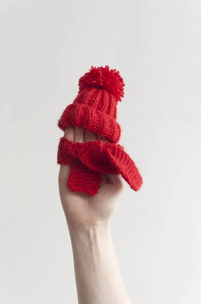 Röd stickad mössa och halsduk på kvinnlig hand — Stockfoto