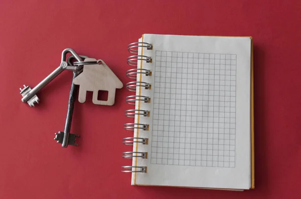 Início chave e livro de notas sobre fundo papel vermelho, espaço de cópia. Material de transporte — Fotografia de Stock