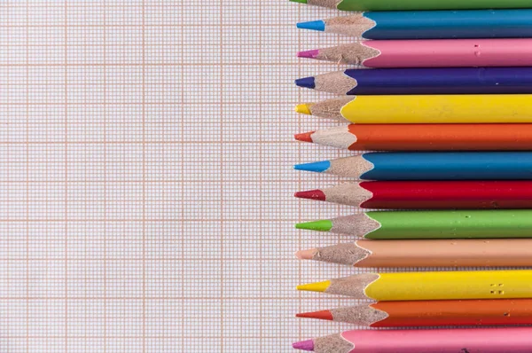 Ołówki kolorowe i tło papieru — Zdjęcie stockowe