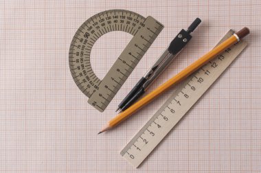 Grafik kağıdındaki pusula, kalem ve cetvel ile geometri seti