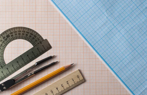 Grafik kağıdındaki pusula, kalem ve cetvel ile geometri seti