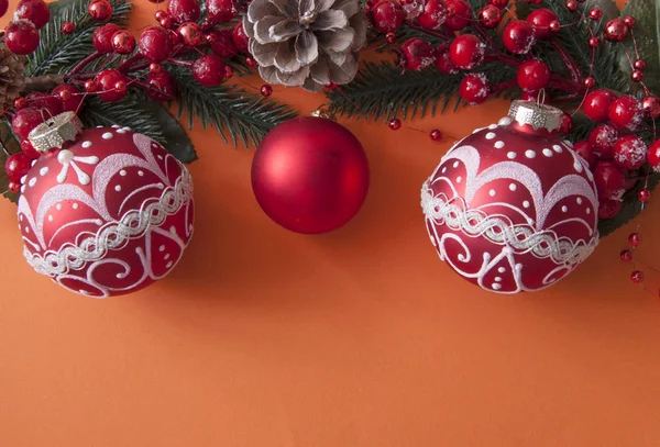 Bolas de Natal, bagas e cones com espaço de cópia em papel vermelho — Fotografia de Stock