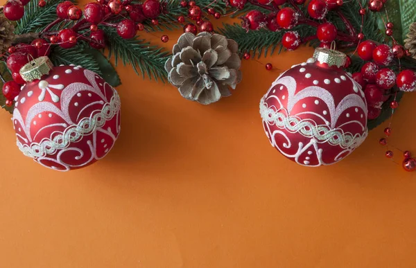 Bolas de Natal, bagas e cones com espaço de cópia em papel vermelho — Fotografia de Stock