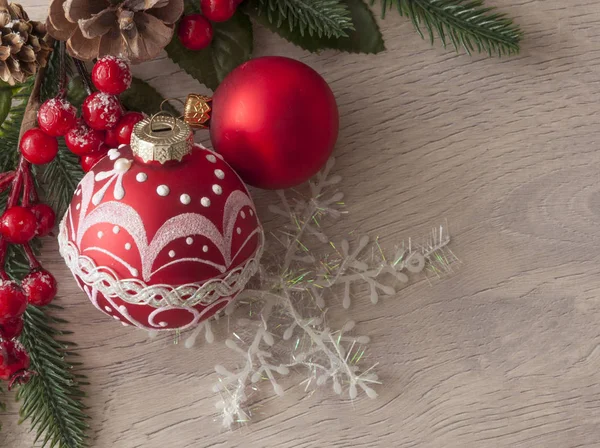 Sfondo natalizio con ramoscelli di abete, bacche rosse, coni e palla — Foto Stock