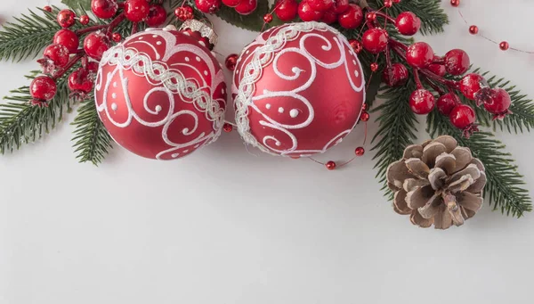 Bolas de Navidad, bayas y conos con espacio de copia en pape blanco — Foto de Stock