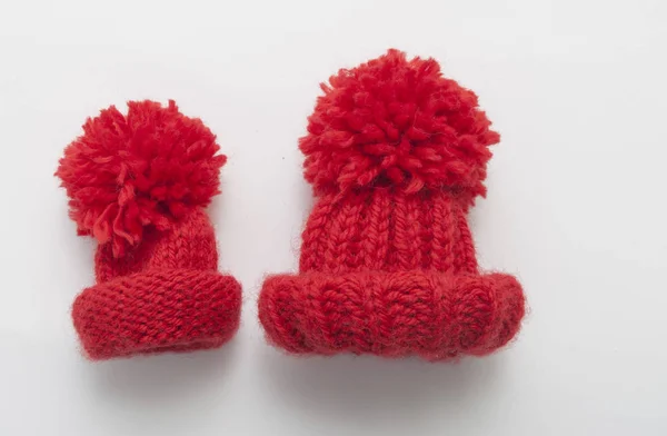 Red knitted wool beanie hat on white table top view. — Stock Photo, Image