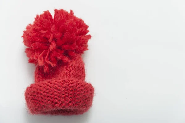 Red knitted wool beanie hat on white table top view. — Stock Photo, Image