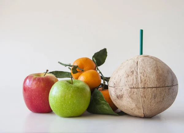 Mischobst: Kokosnuss, frische Äpfel und Mandarinen mit grünem Blatt — Stockfoto