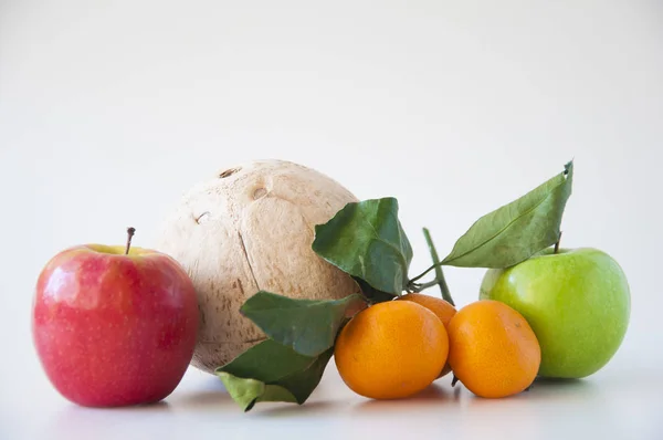 Vegyes gyümölcs: kókusz, friss alma és mandarin zöld levéllel — Stock Fotó