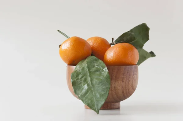 Bund reife, saftige, orangefarbene Mandarinen mit Blättern auf weißem Rücken — Stockfoto